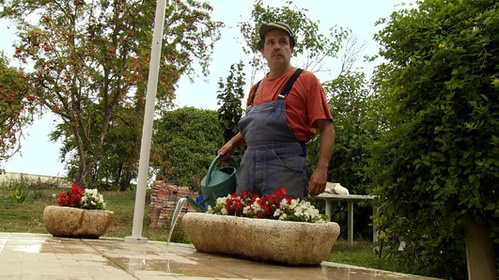homme arrose ses fleurs