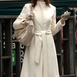 anne hathaway avec un manteau blanc