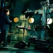 costas mandylor devant une machine