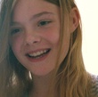 Elle Fanning sourit