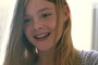 Elle Fanning sourit